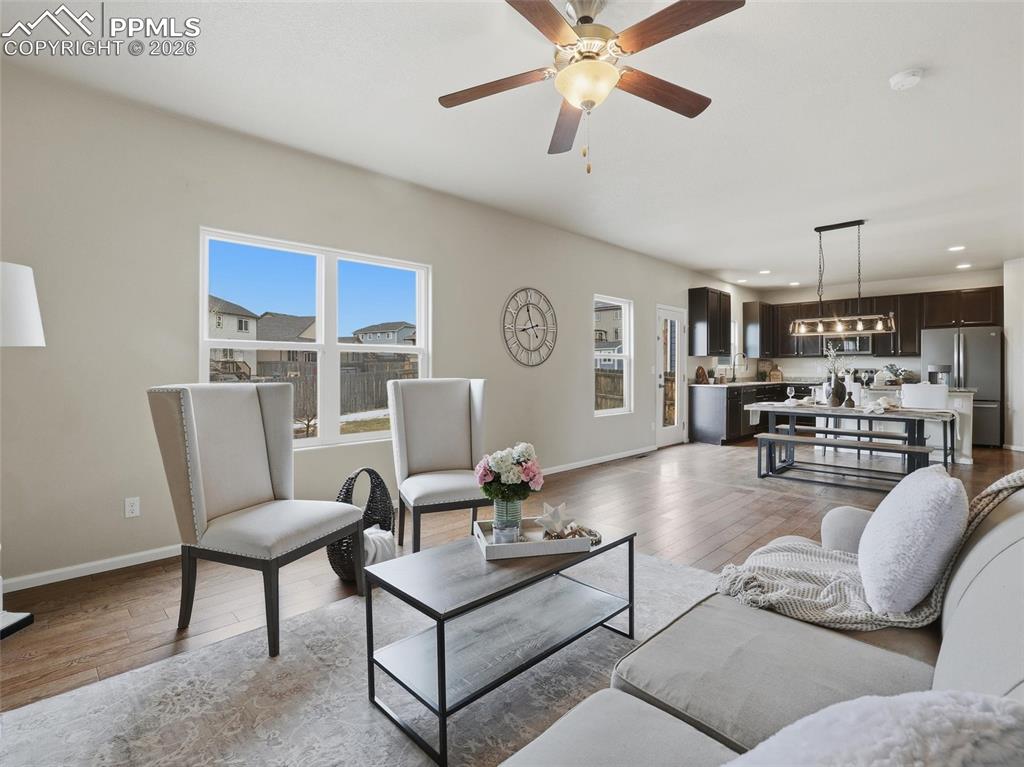 Living room with light wood-type flooring, recessed lighting, and a ceiling fan