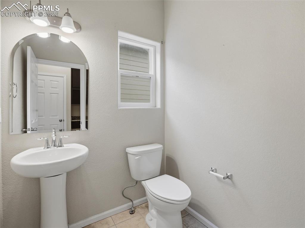 Bathroom featuring light tile patterned flooring and a textured wall
