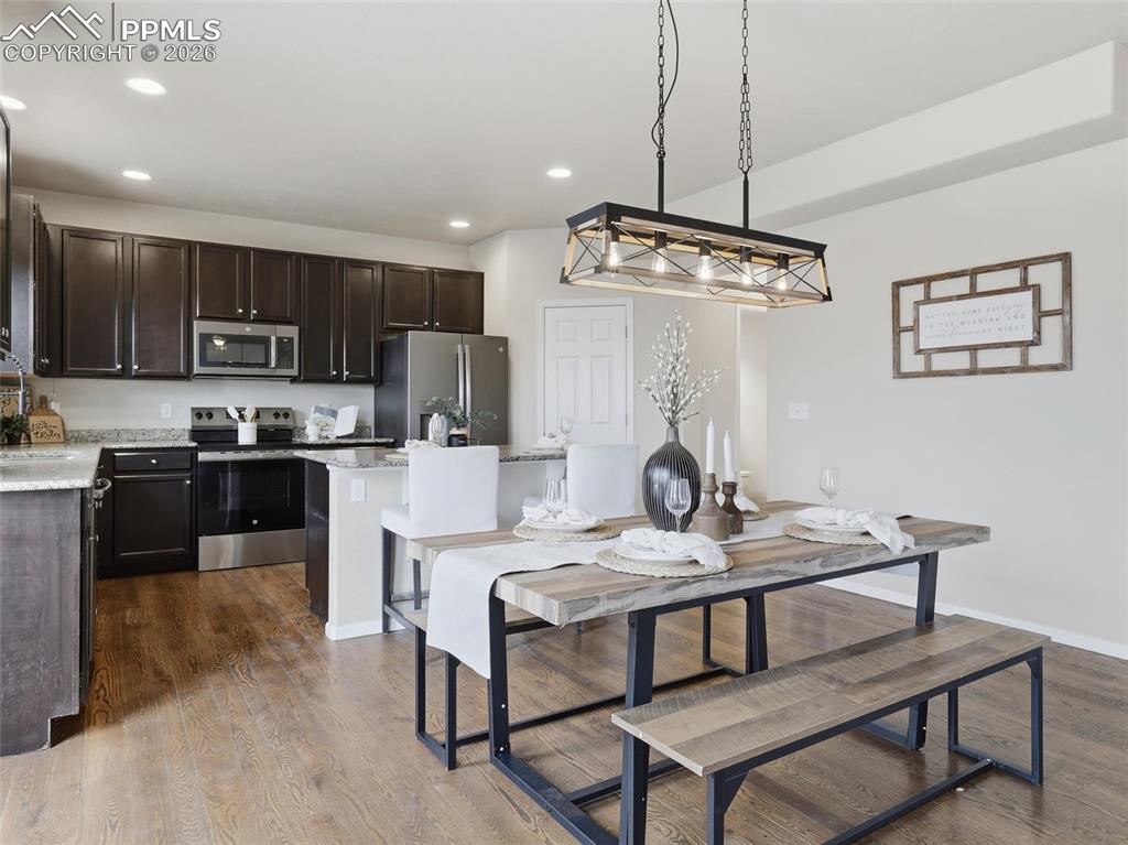 Dining area with dark wood-style flooring and recessed lighting