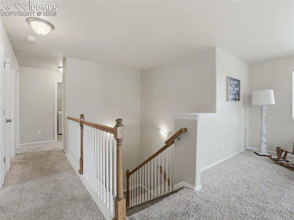 Hall featuring carpet and an upstairs landing
