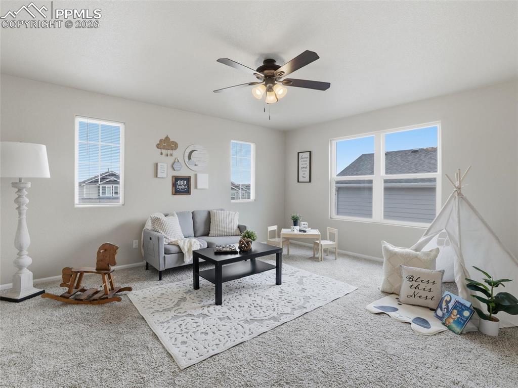 Living room featuring carpet flooring and a ceiling fan