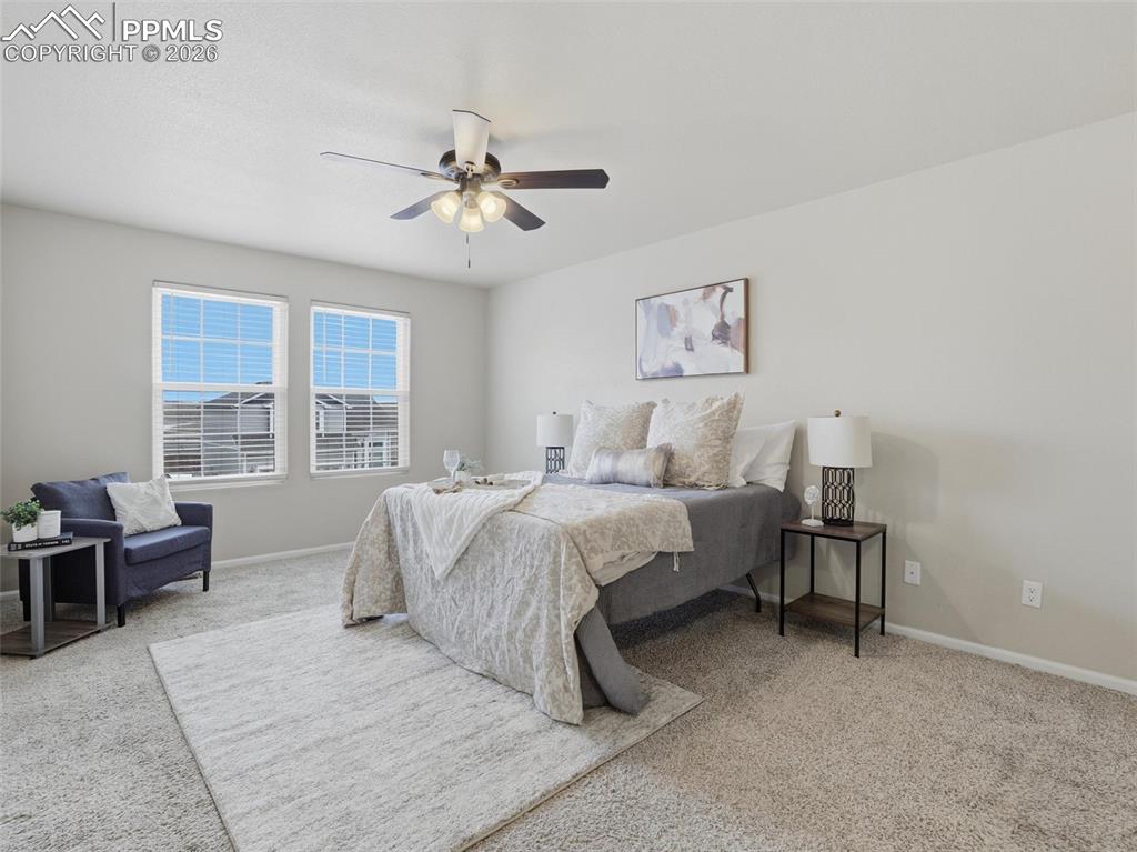 Bedroom with light carpet and a ceiling fan