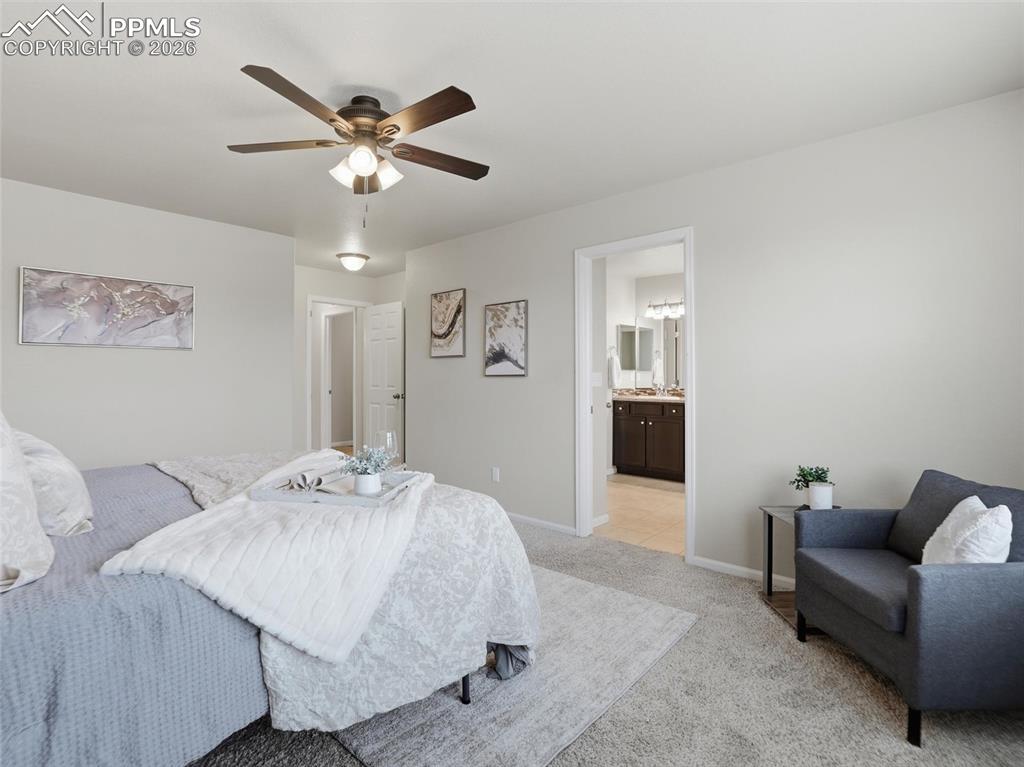 Carpeted bedroom with a ceiling fan and baseboards