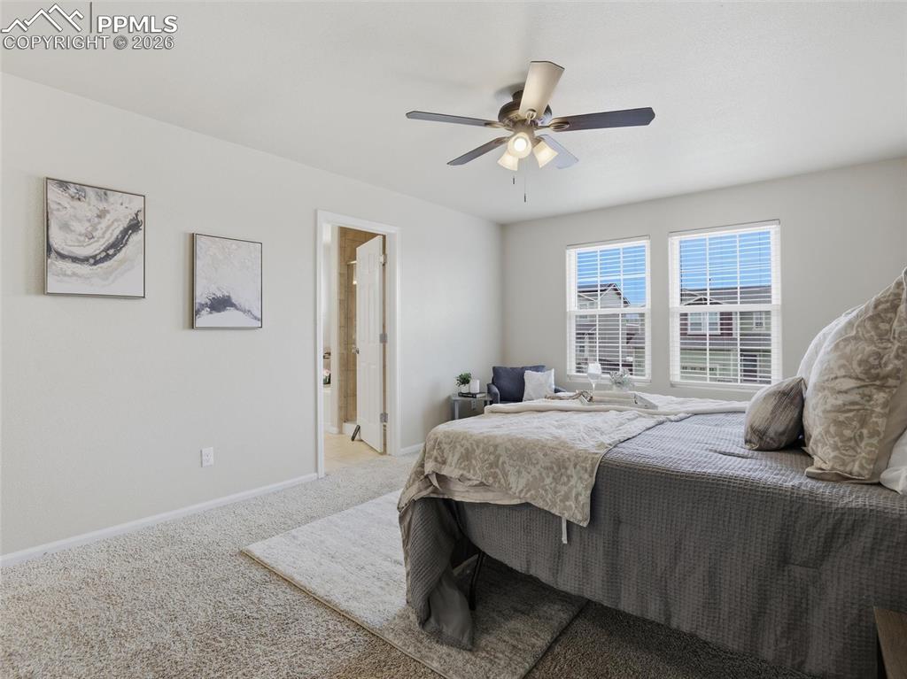 Carpeted bedroom with baseboards and a ceiling fan