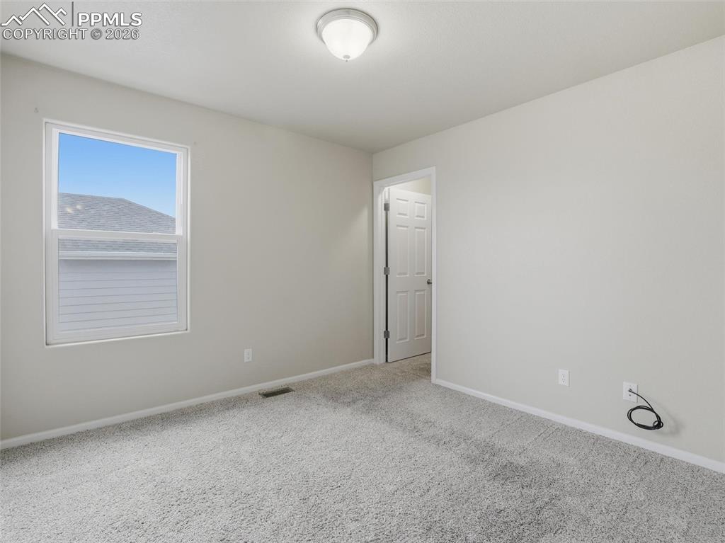 Carpeted spare room with baseboards