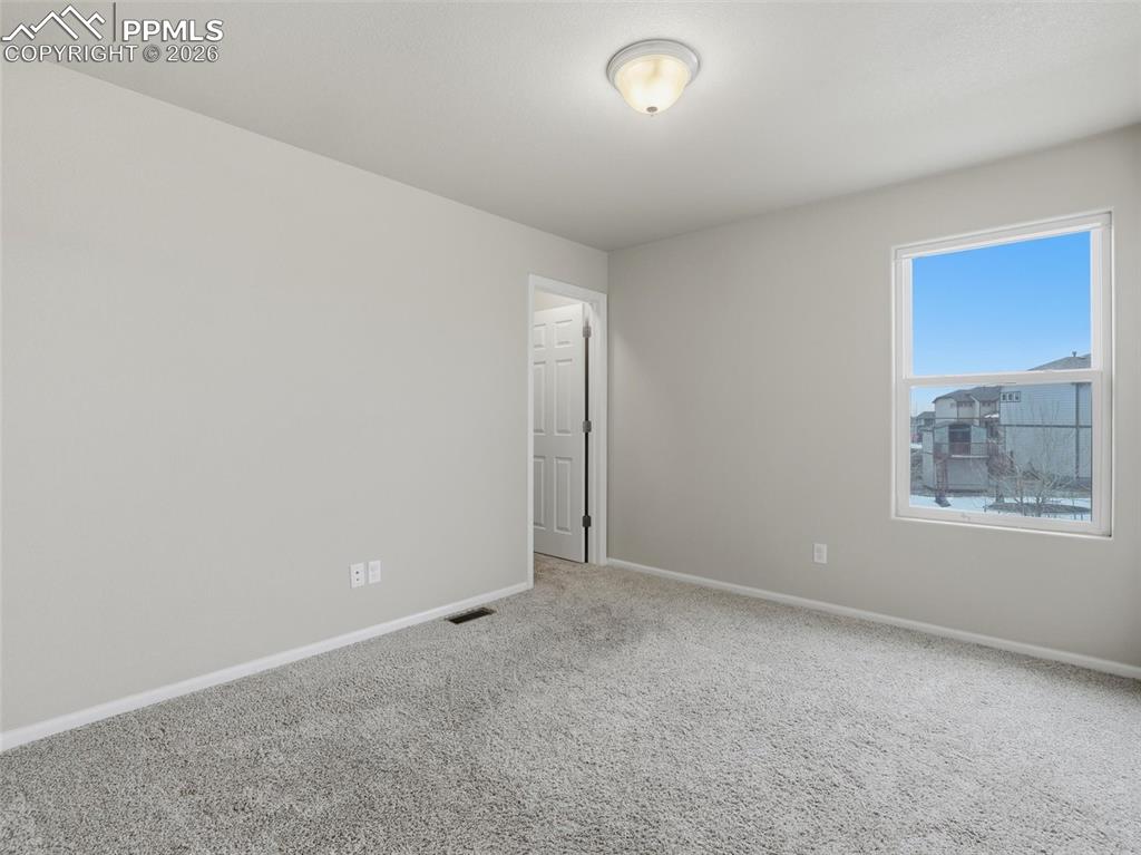 Spare room with baseboards and carpet