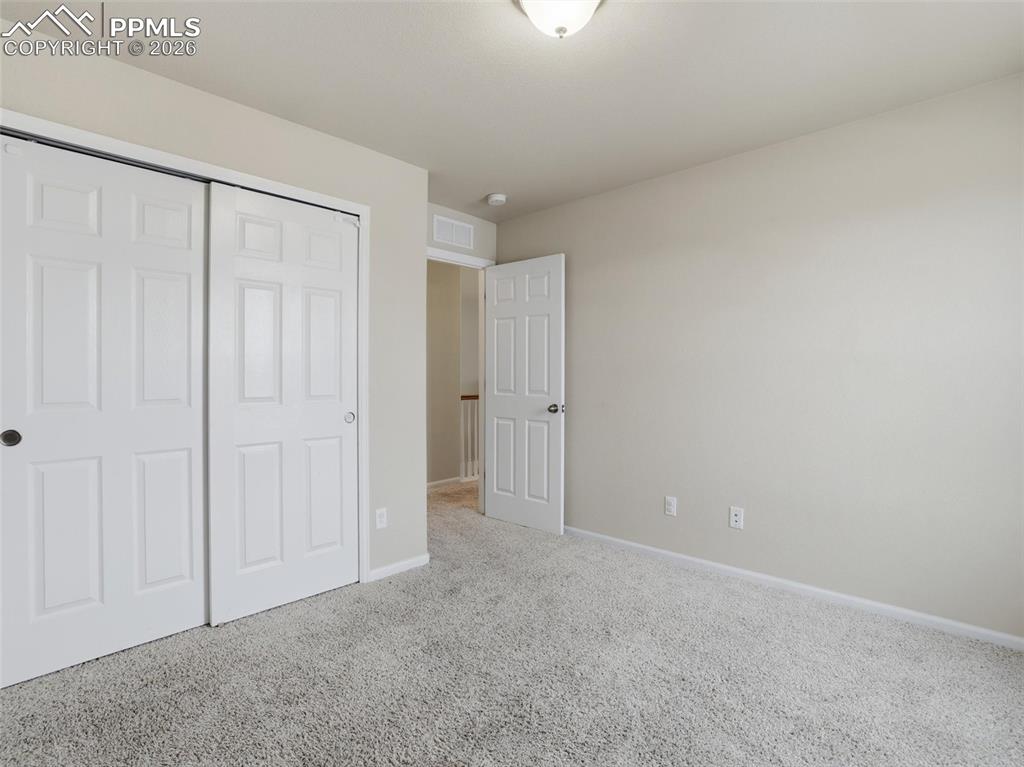 Unfurnished bedroom featuring carpet flooring and a closet