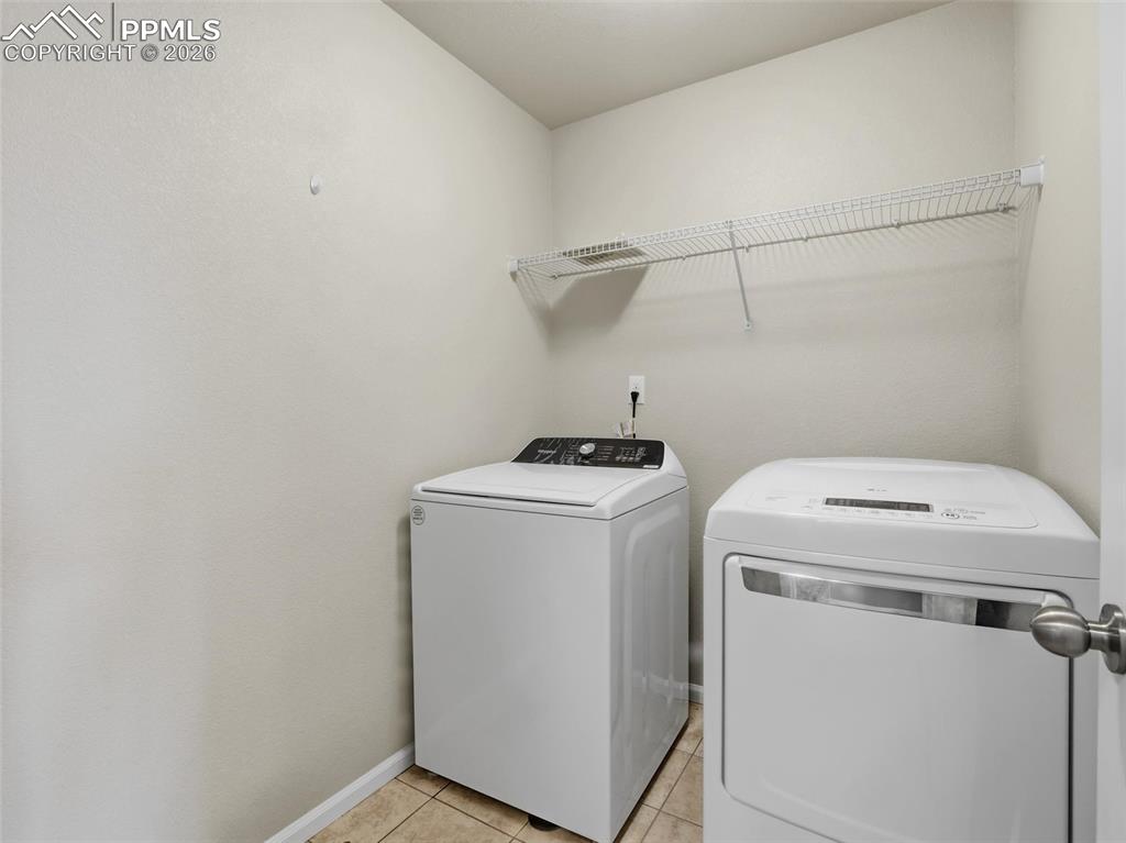 Laundry room featuring washing machine and dryer and light tile patterned flooring