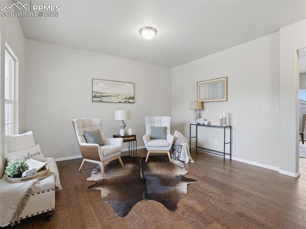 Living area with dark wood-type flooring and baseboards