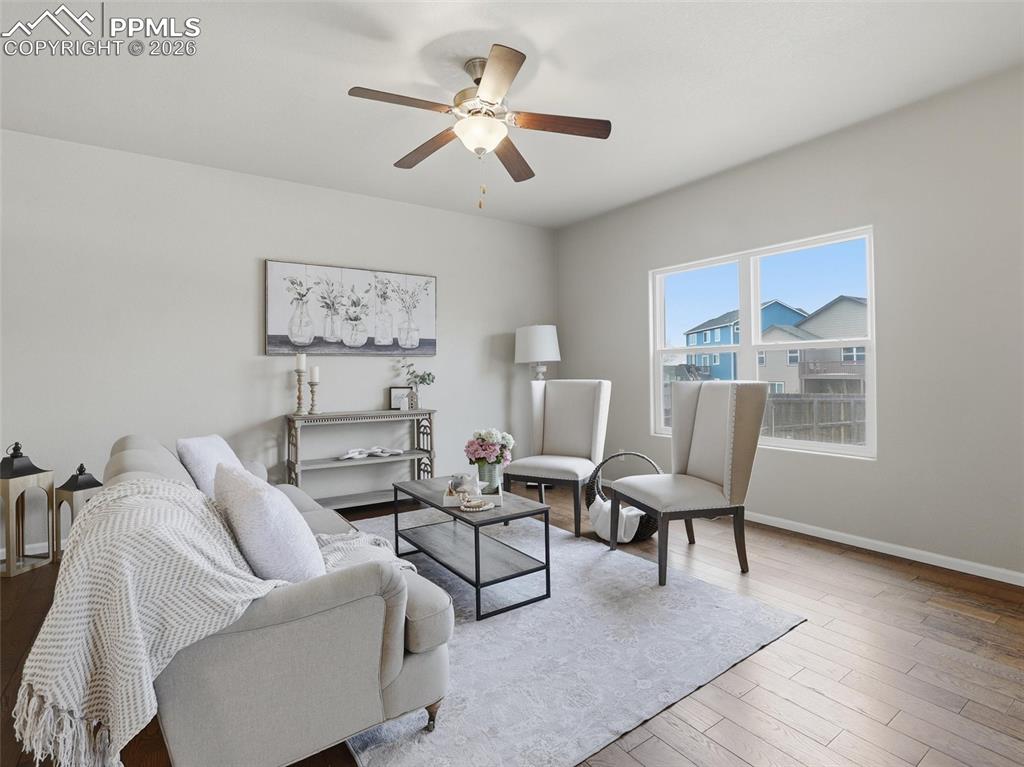 Living area featuring light wood finished floors and ceiling fan