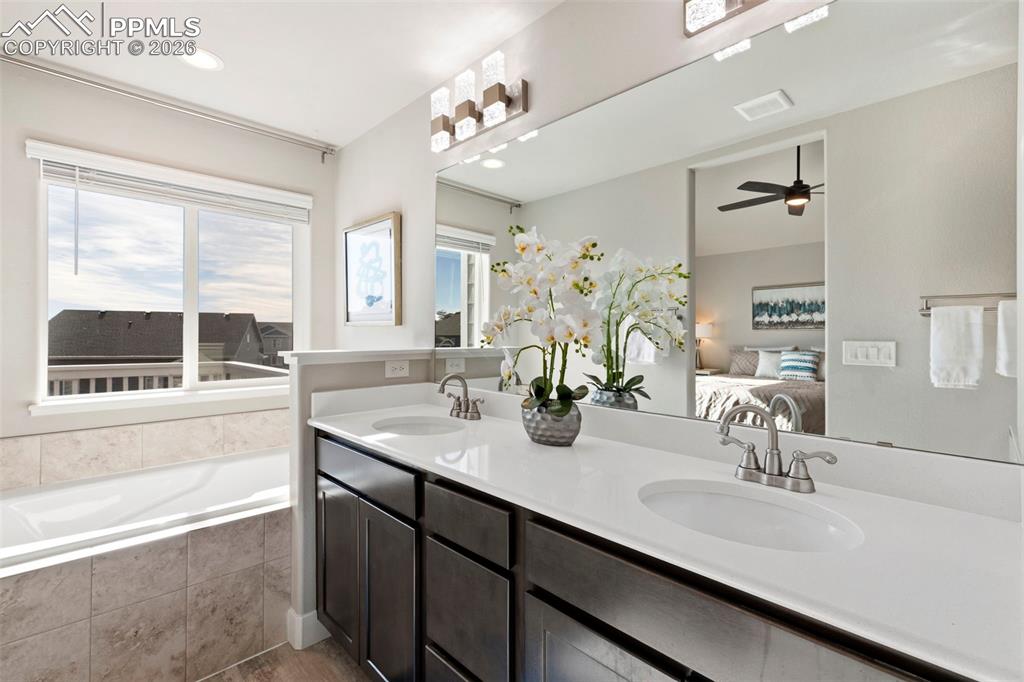 Bathroom featuring connected bathroom, a bath, double vanity, a ceiling fan, and recessed lighting