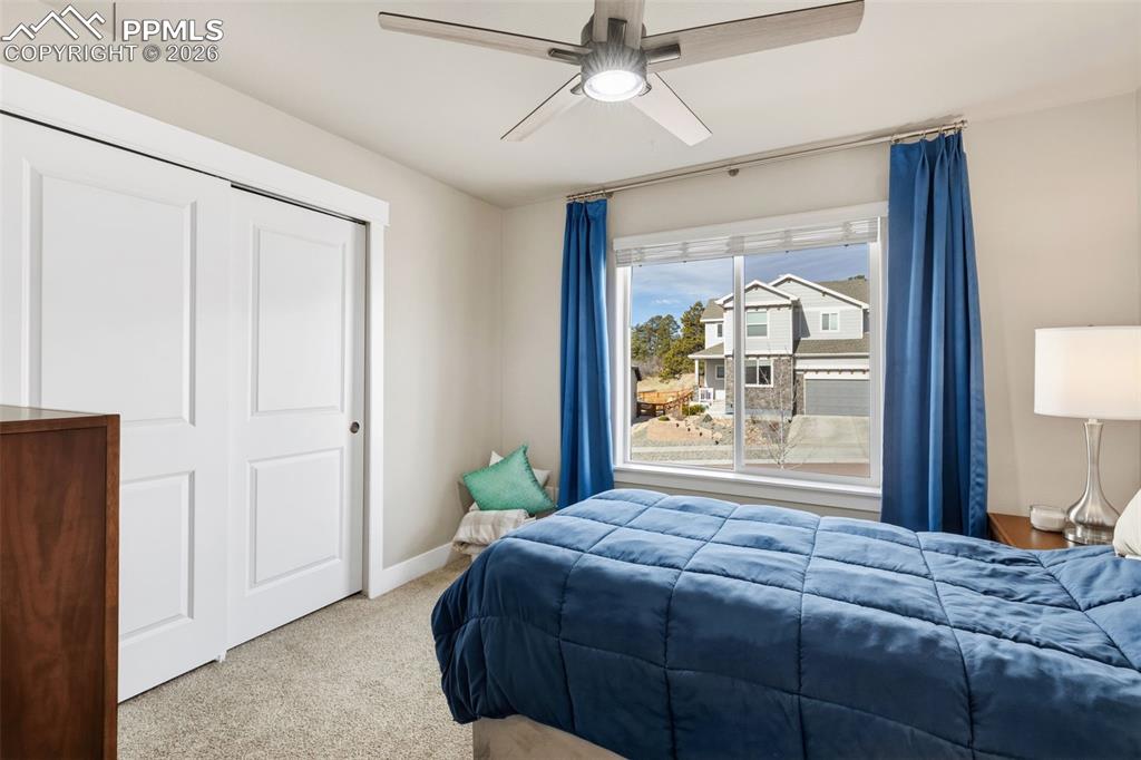 Carpeted bedroom with a closet and ceiling fan