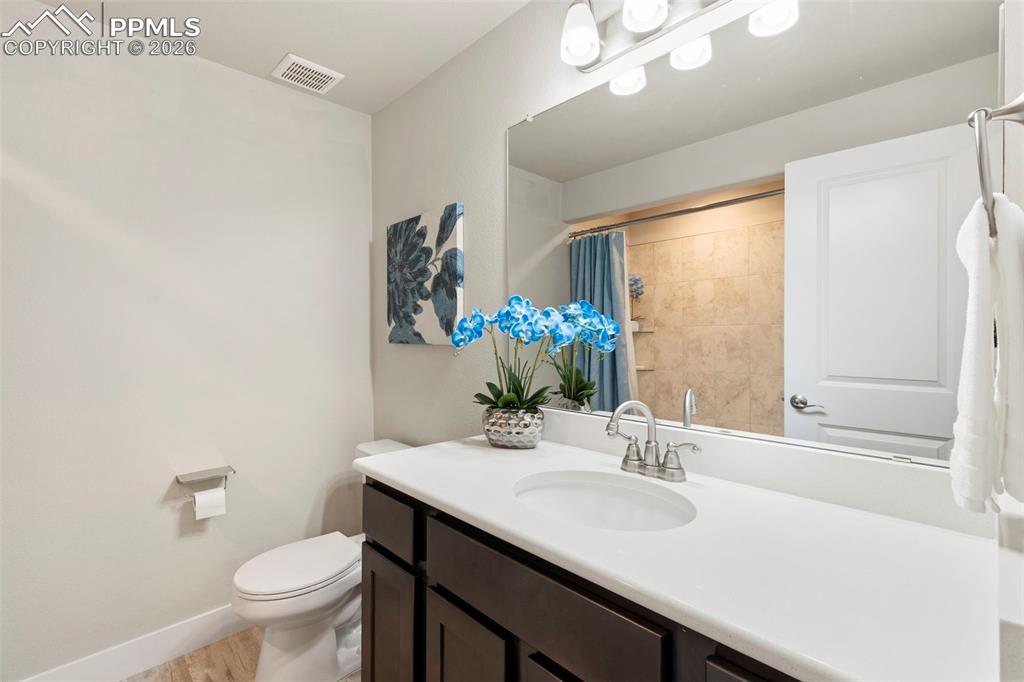 Full bath featuring vanity, a shower with shower curtain, and light wood-style floors