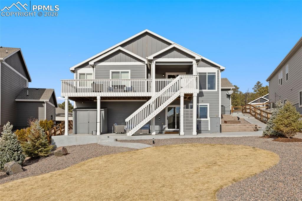 Back of house with a patio area, board and batten siding, and a deck