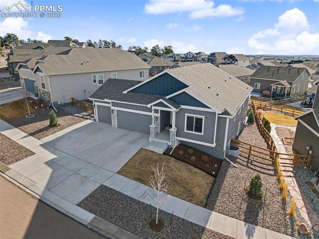 View of front of house with board and batten siding, a garage, a shingled roof, and a residential view