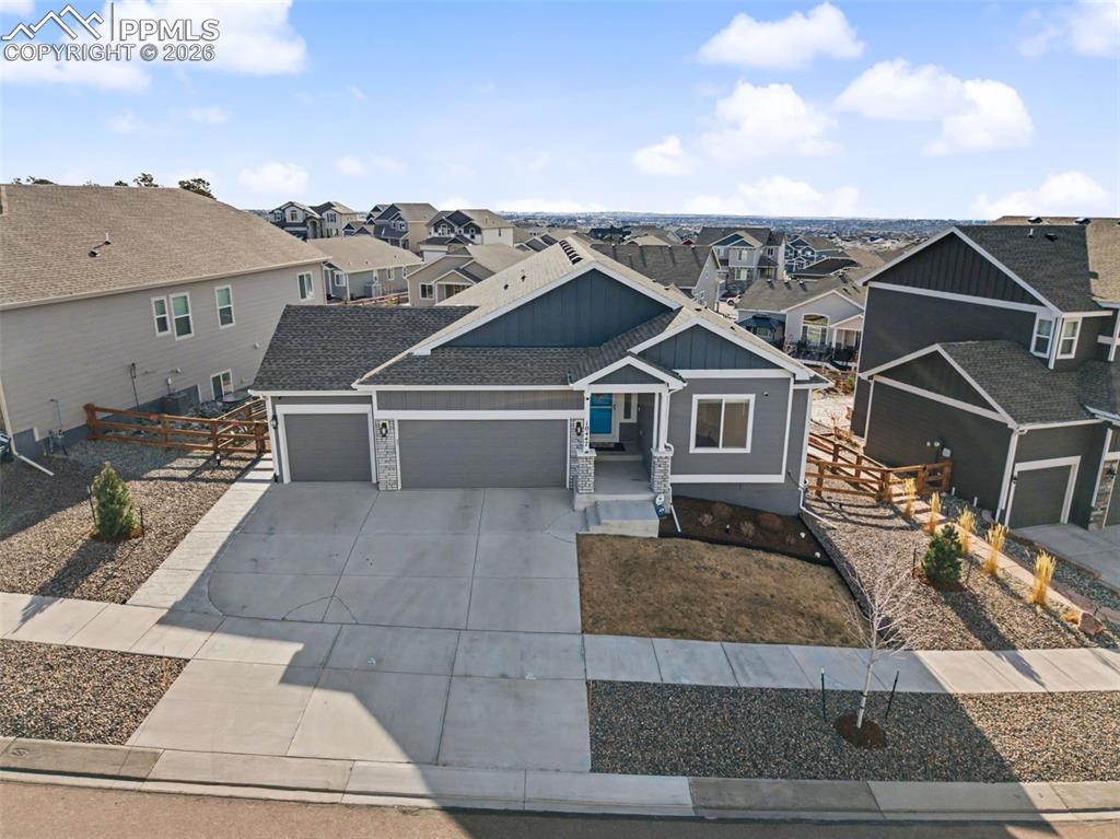 Craftsman house with a garage, board and batten siding, a residential view, and concrete driveway