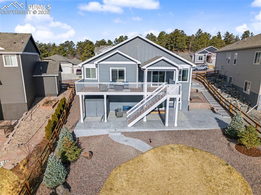 Back of property with a patio, board and batten siding, a wooden deck, and a residential view