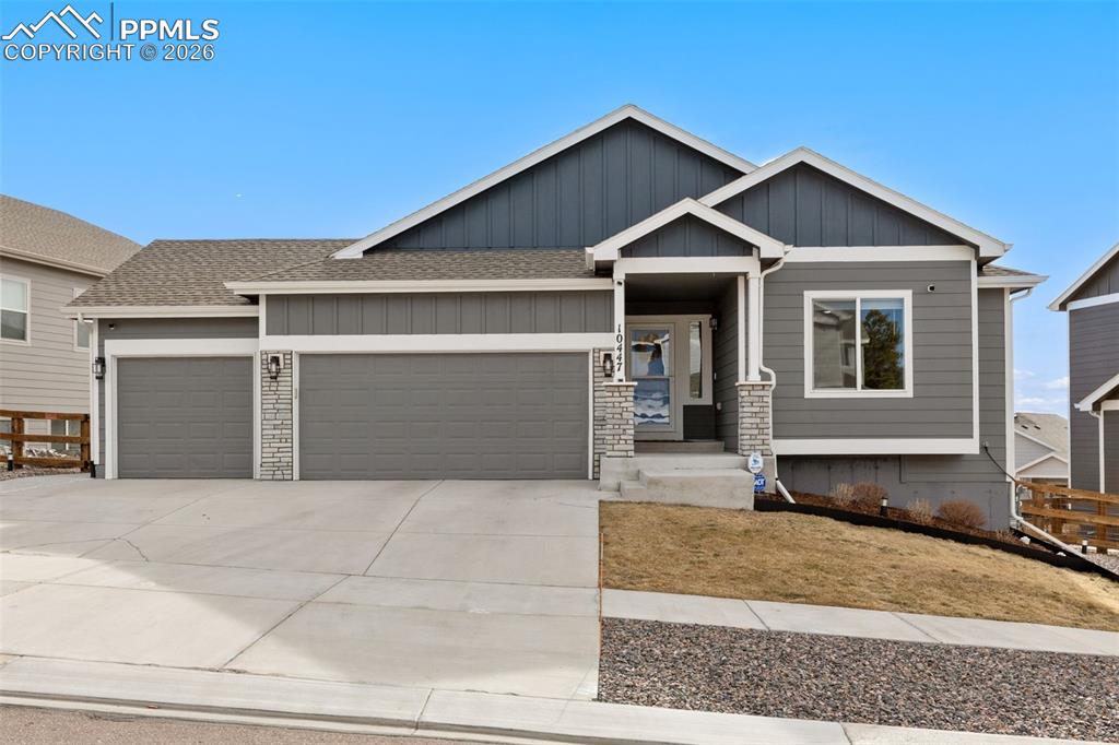 View of front of home with a garage, concrete driveway, roof with shingles, and board and batten siding