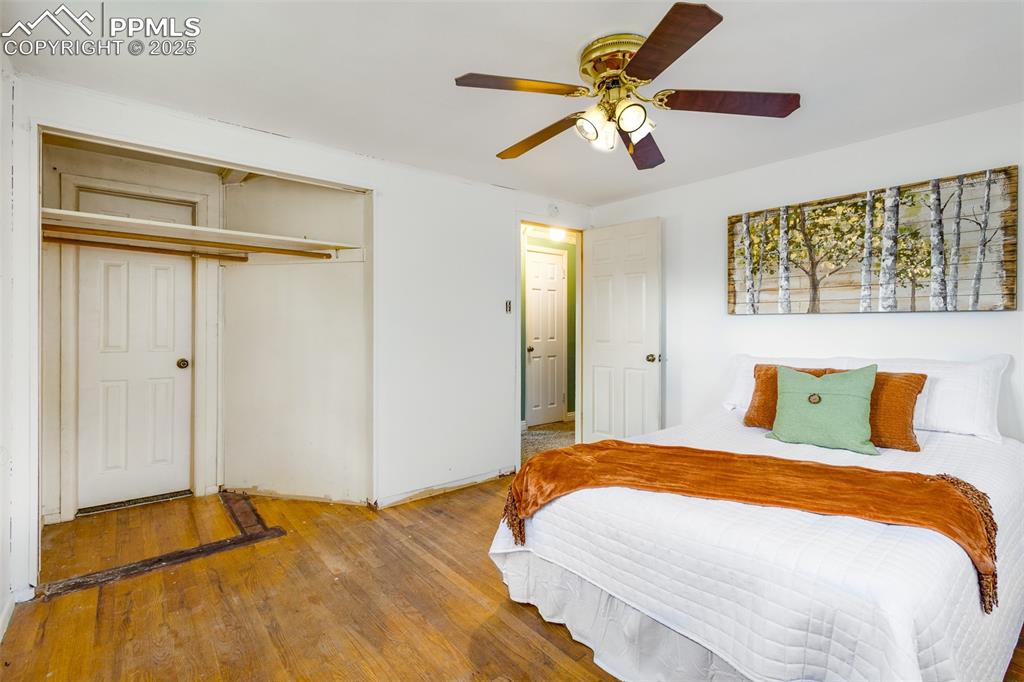 Bedroom featuring wood-type flooring, ceiling fan, and a closet