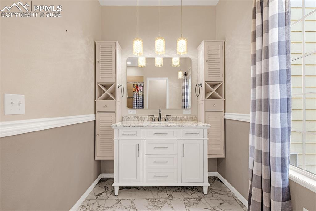 Main level master suite bathroom has fresh finishes with marble look tile
