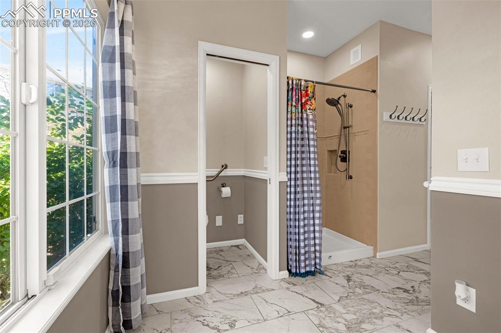 This bathroom has been equipped with handicap rails, wide hallway and shower