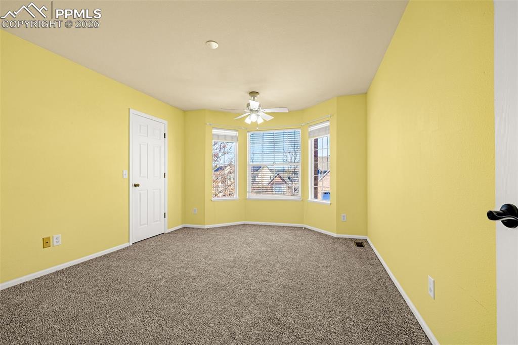 This upper level bedroom boasts a bay window and sunshine colored walls