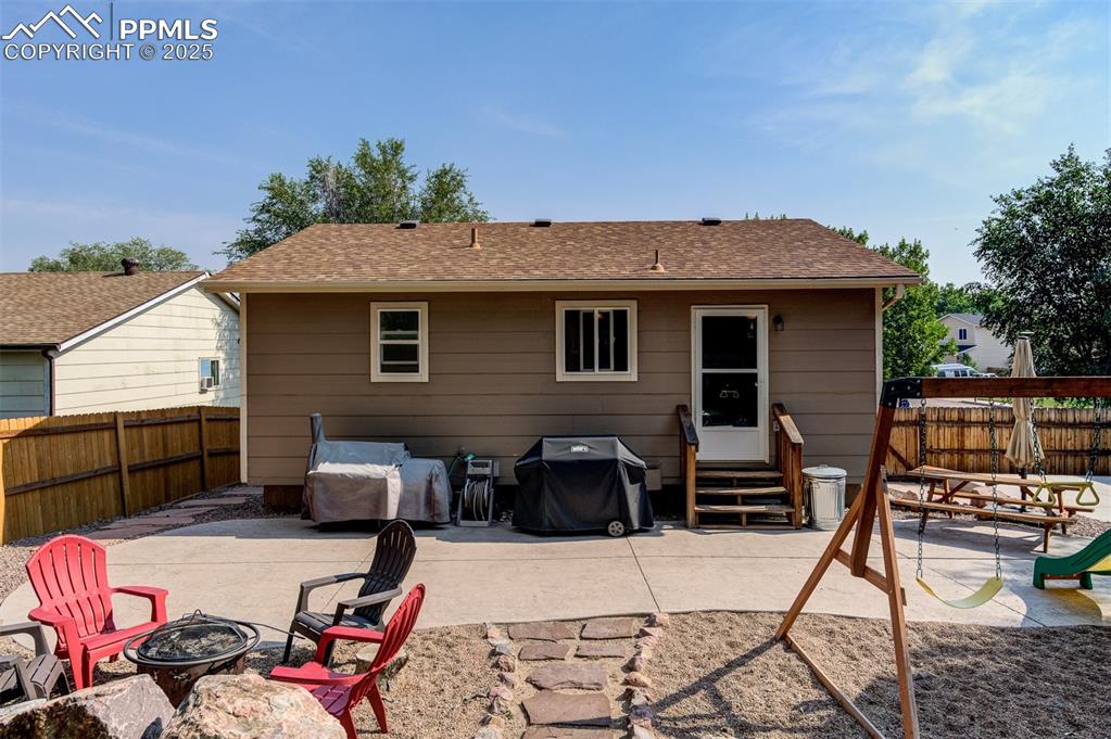 Rear view of property with entry steps, an outdoor fire pit, a patio, and a fenced backyard