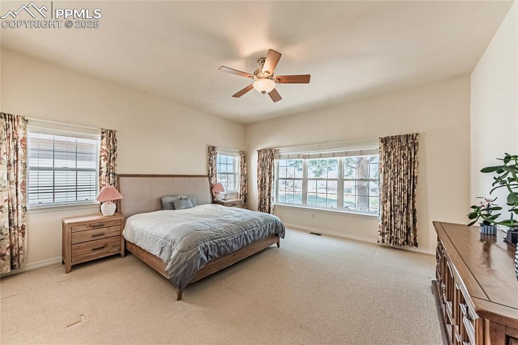 Bedroom featuring baseboards, a ceiling fan, and carpet