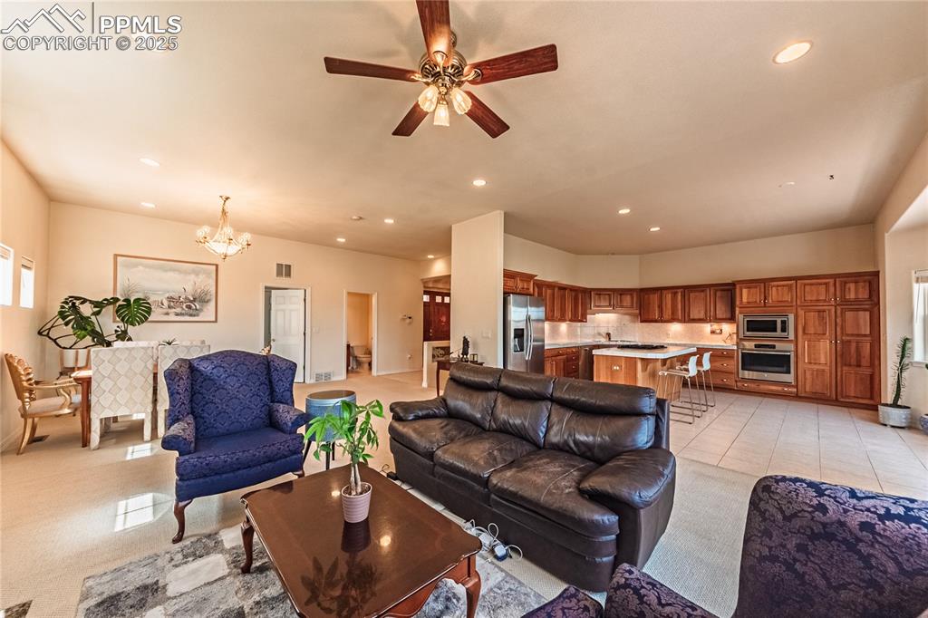 Living room featuring visible vents, recessed lighting, and ceiling fan with notable chandelier