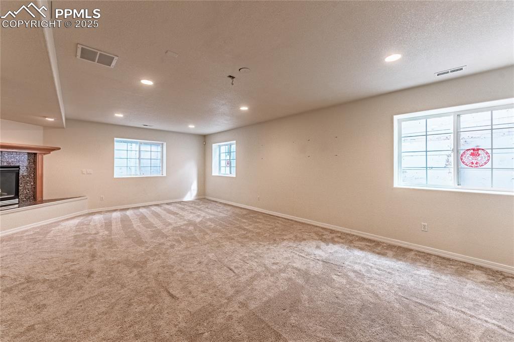 Below grade area with visible vents, recessed lighting, and carpet