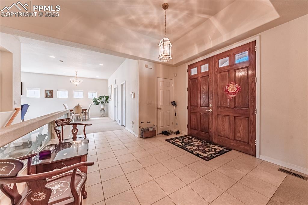 Entryway featuring visible vents, recessed lighting, a chandelier, light tile patterned flooring, and baseboards