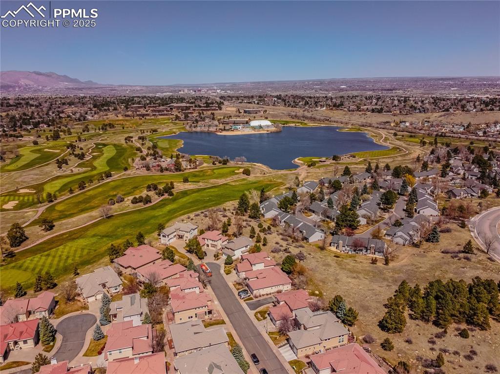 Drone / aerial view featuring view of golf course, a residential view, and a water and mountain view