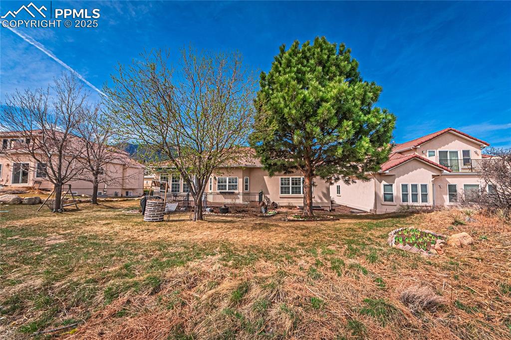 Back of property with stucco siding and a lawn
