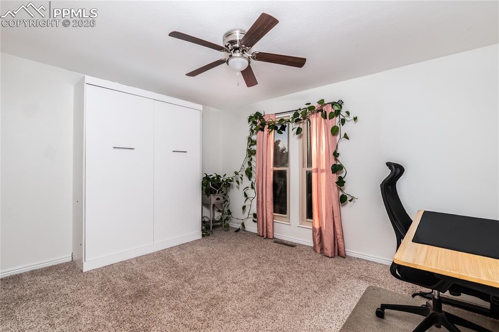 Office space with light colored carpet and a ceiling fan