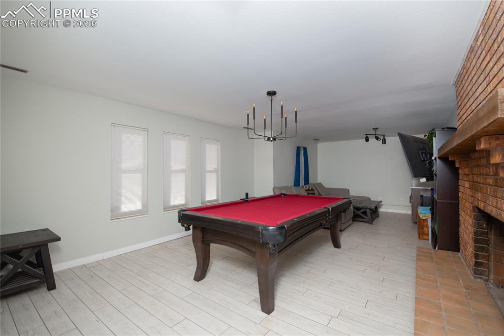 Rec room featuring billiards, a fireplace, and light wood-type flooring