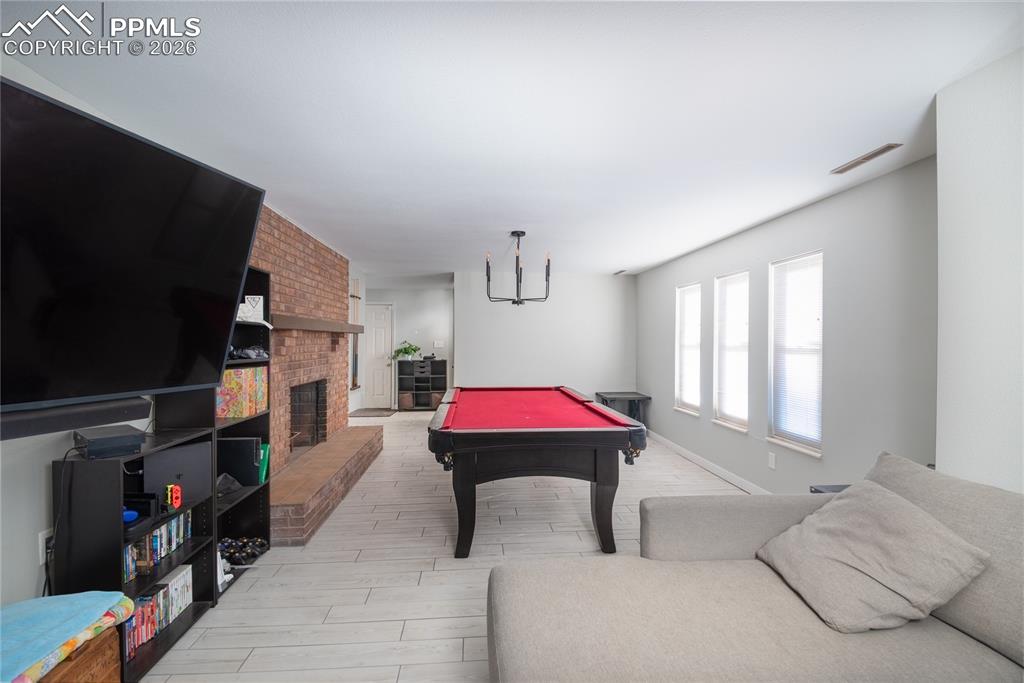 Rec room featuring billiards table, a fireplace, and wood tiled floors
