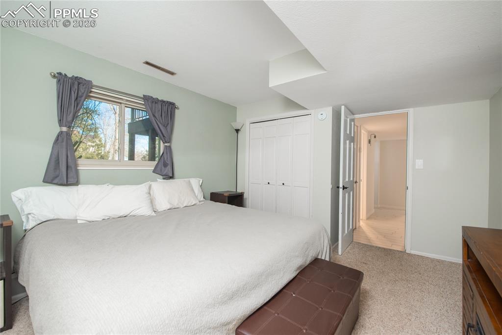 Bedroom with light colored carpet and a closet