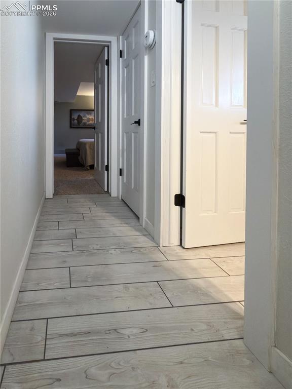 Hallway featuring light wood-type flooring and baseboards