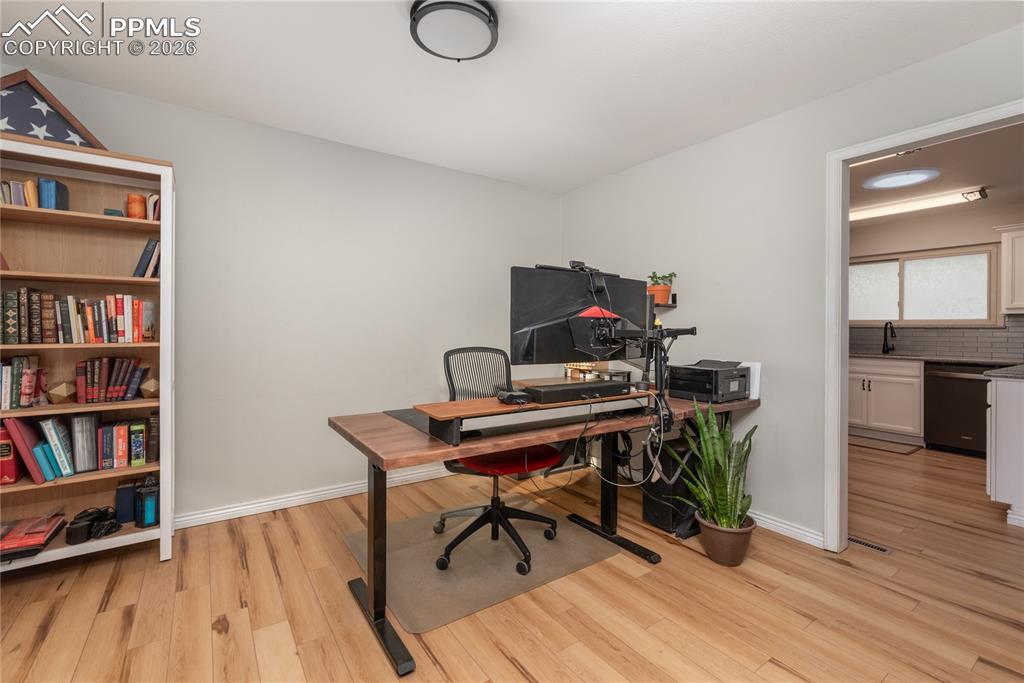 Office area featuring light wood-style floors and baseboards