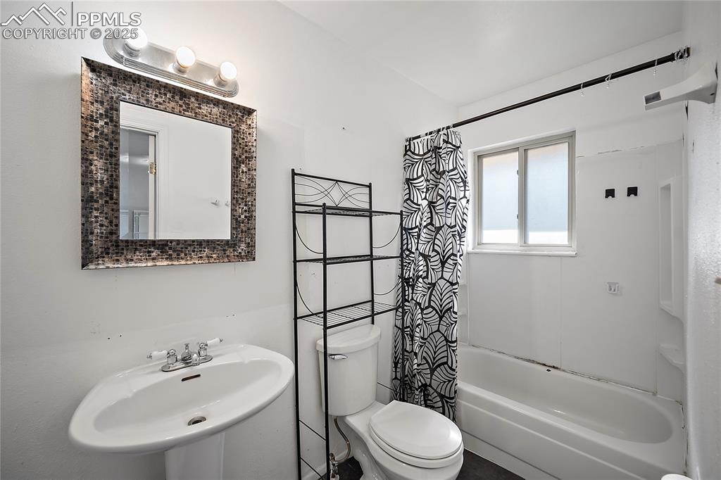 Full bath with shower / bathtub combination with curtain and toilet