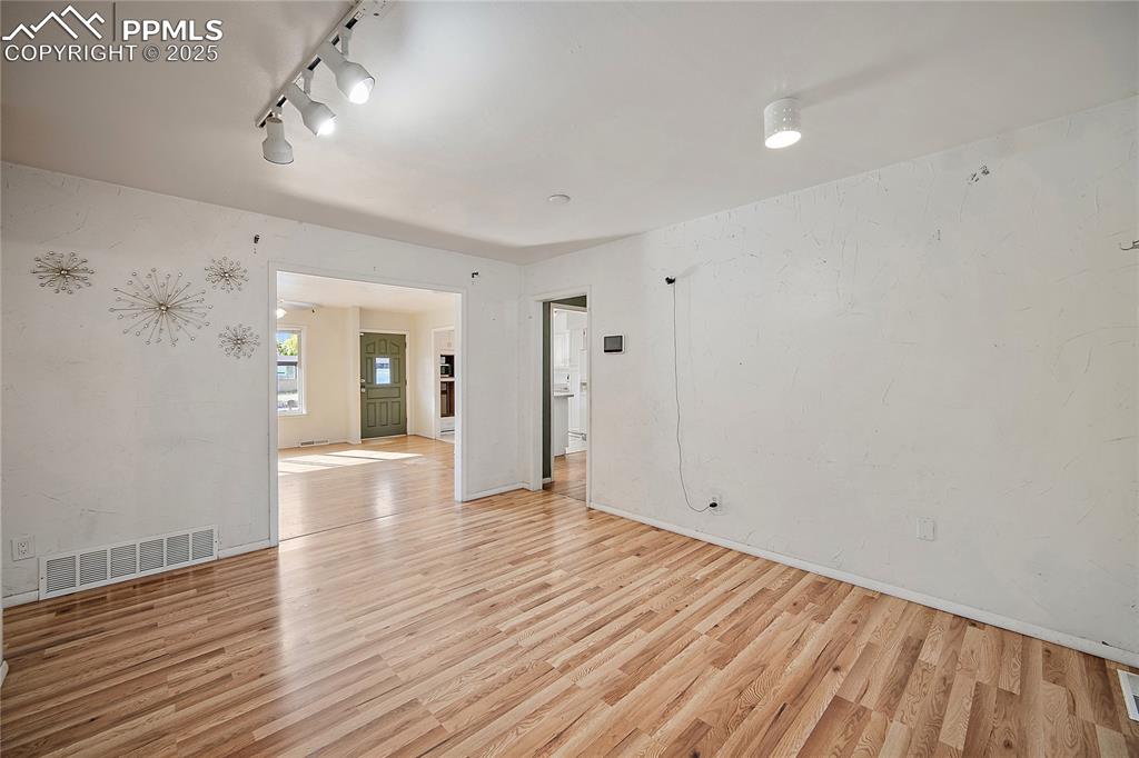 Unfurnished room featuring light wood finished floors and baseboards