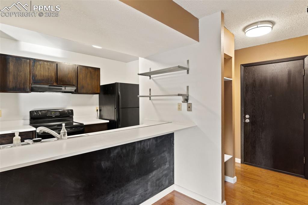 Chalk wall under breakfast bar and built-in open shelving