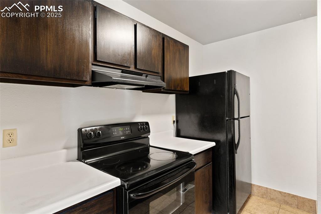 Black kitchen appliances, including range/oven, refrigerator, and dishwasher