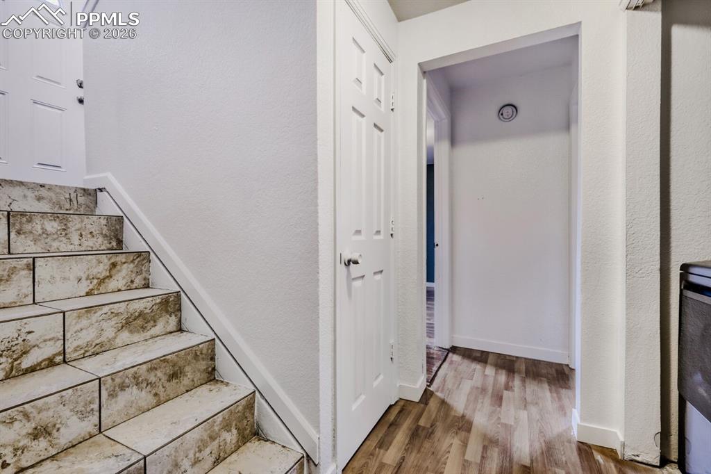 Stairs to lower level with a textured wall and tile finished floors