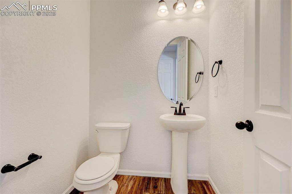 Bathroom with toilet and wood finished floors