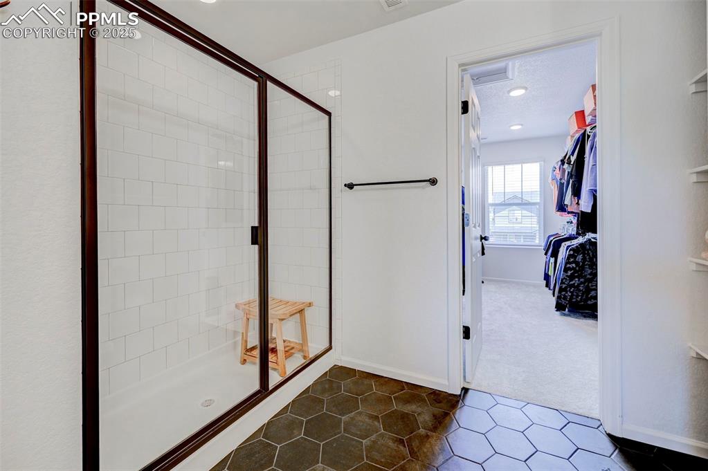 Full bath with a stall shower and tile patterned flooring