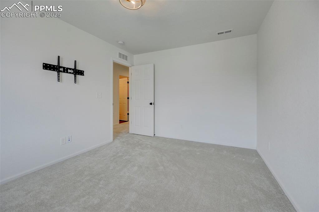 Carpeted spare room featuring baseboards