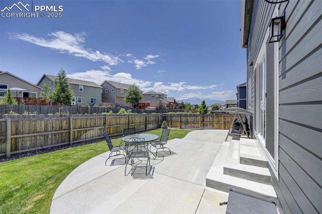 Fenced backyard featuring a residential view, a patio area, and outdoor dining area