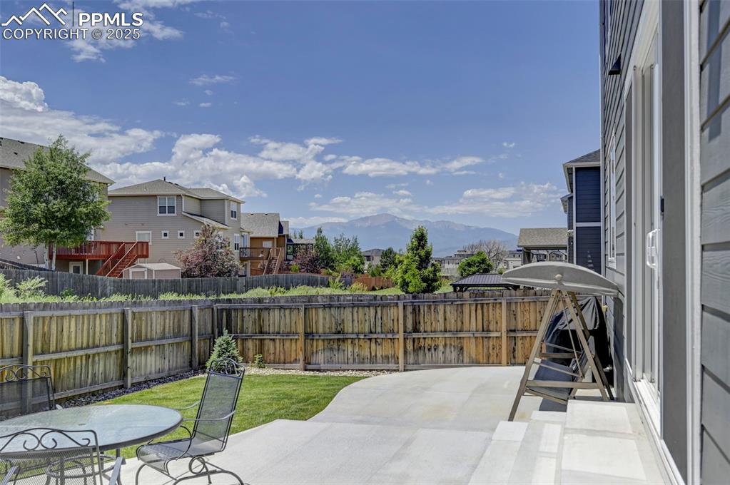 Fenced backyard featuring a residential view, a patio, and a mountain view