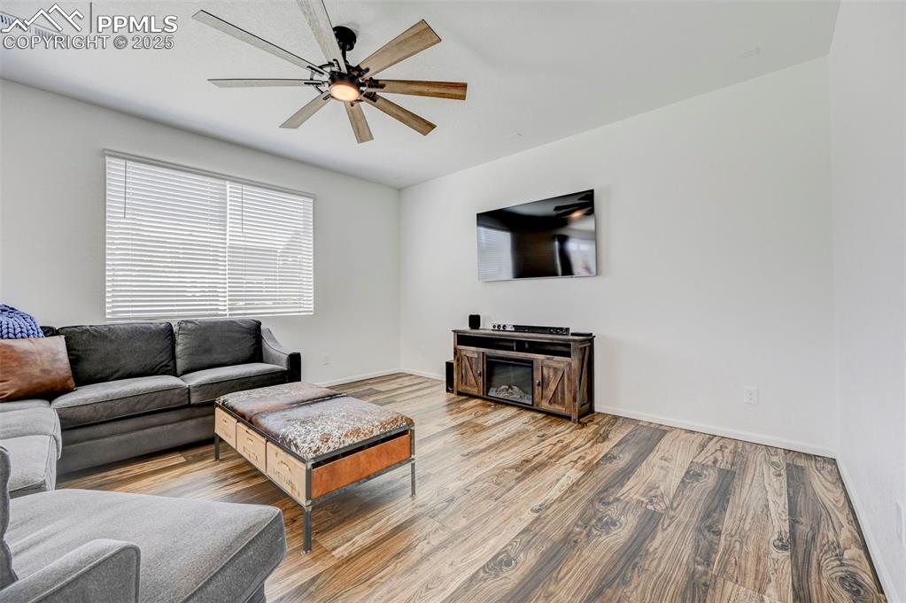 Living area featuring ceiling fan and wood finished floors